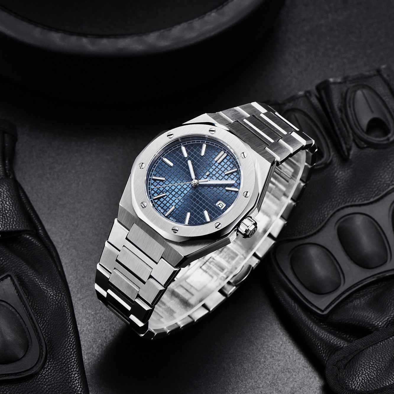 Silver watch with blue face on a dark textured surface