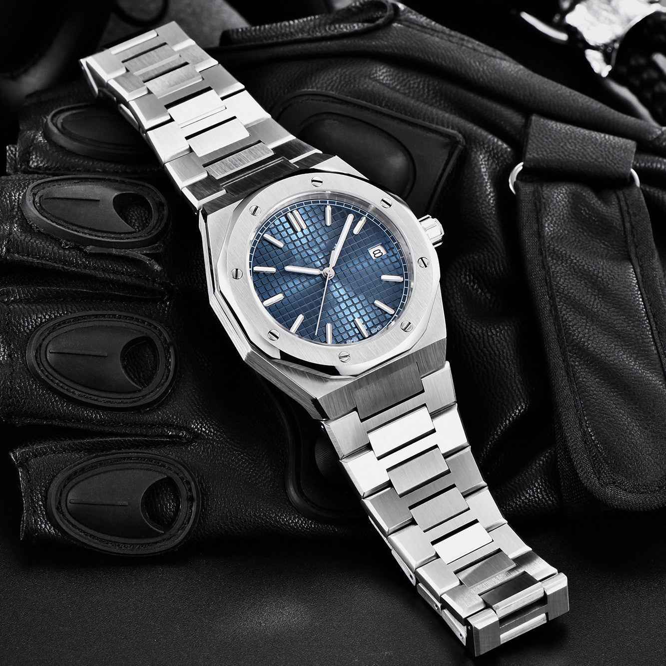Silver watch with blue face on a dark background